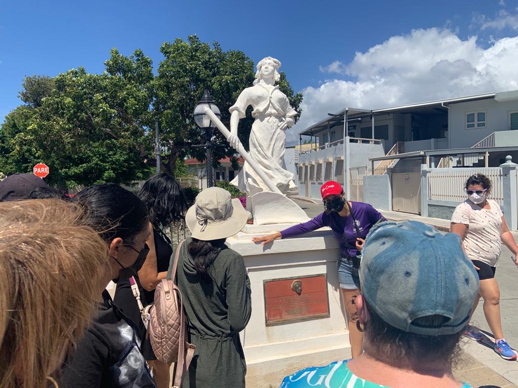 Personas observan  la placa de la cantante de Ópera Graciela Rivera, y la estatua creada por Víctor Cott que representa a la mujer labradora.