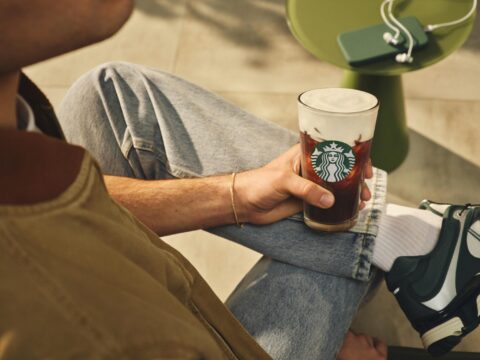 Consumidor sostiene una bebida Starbucks con Protein Cold Foam durante la temporada de verano.