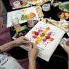 Participantes trabajan con flores, textiles y martillos en el taller mensual “Hammering Flowers” en San Juan.