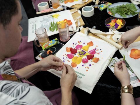 Participantes trabajan con flores, textiles y martillos en el taller mensual “Hammering Flowers” en San Juan.