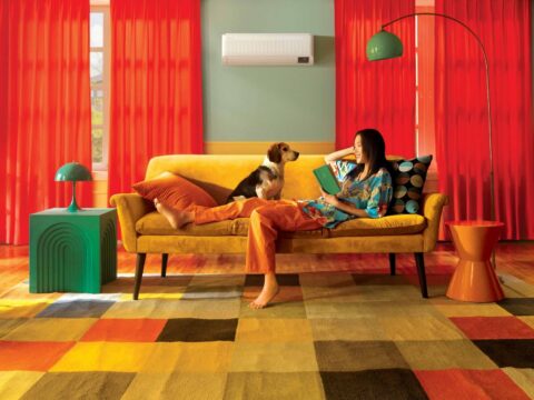 ¿Tu mascota se queda sola? Samsung apuesta por climatización inteligente para mantenerla cómoda Perro descansa en el mueble de una sala mientras un aire acondicionado Samsung enfría el espacio.