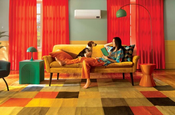 ¿Tu mascota se queda sola? Samsung apuesta por climatización inteligente para mantenerla cómoda Perro descansa en el mueble de una sala mientras un aire acondicionado Samsung enfría el espacio.