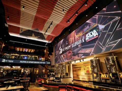 Abre sus puertas el BetMGM 21 Sportsbook Lounge en el DISTRITO T-Mobile de San Juan Fotografía interior del lounge mostrando la combinación de colores negro y dorado de BetMGM.