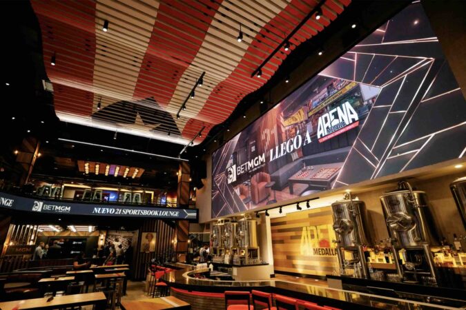 Abre sus puertas el BetMGM 21 Sportsbook Lounge en el DISTRITO T-Mobile de San Juan Fotografía interior del lounge mostrando la combinación de colores negro y dorado de BetMGM.