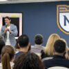 Estudiantes universitarios atentos a una charla de educación financiera en un salón de conferencias.